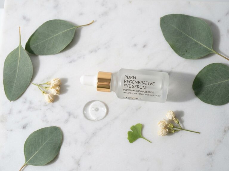 The PDRN skincare eye serum ampoule on white marble surface